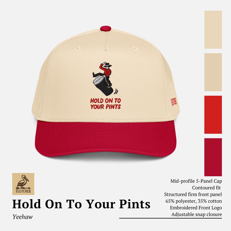 May include: A cream and red baseball cap with the text "HOLD ON TO YOUR PINTS" embroidered on the front. The cap features a cartoon cowboy falling off a barrel. It has an adjustable snap closure and a structured front panel.