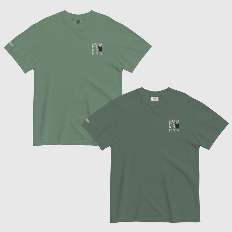 K&ouml;nnte beinhalten: Zwei kurz&auml;rmelige T-Shirts in Gr&uuml;nt&ouml;nen. Jedes Shirt hat den Text "CREAMY F*CKIN PINTS" und eine Grafik eines Pintglases auf der Vorderseite. Die Shirts werden vor einem hellgrauen Hintergrund gezeigt.