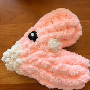 May include: A pink heart-shaped plush toy with white polka dots and black eyes.
