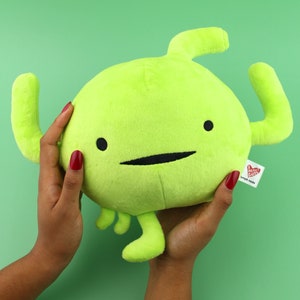 May include: A lime green plush toy shaped like a human kidney with a smiling face. The toy has two arms and two legs. The toy has a red tag that says "Heart Guts" and "simply made".