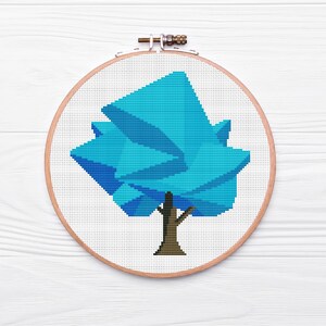 May include: A blue geometric tree cross-stitch pattern in a wooden embroidery hoop.