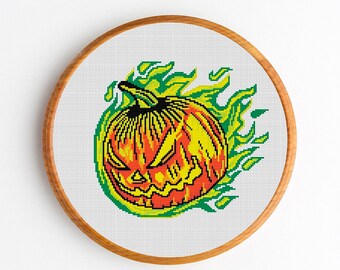May include: A cross-stitch pattern of a jack-o'-lantern pumpkin with a menacing expression, surrounded by green and yellow flames.