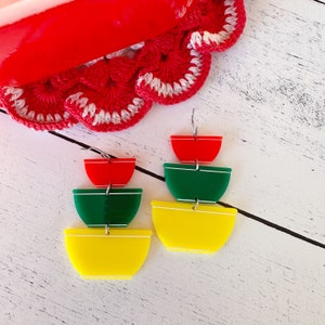 May include: A pair of earrings with three stacked bowls. The top bowl is red, the middle bowl is green, and the bottom bowl is yellow.