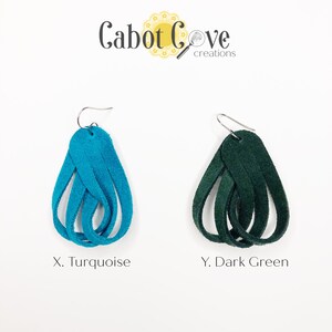 May include: Two pairs of leather earrings, one turquoise and one dark green. The earrings are made of multiple strands of leather that are woven together to create a teardrop shape.