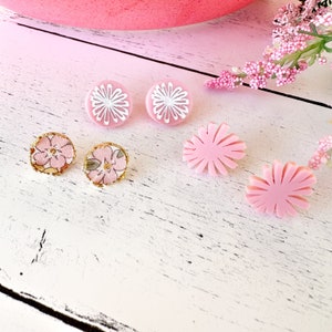 May include: A set of six pink and white floral earrings. The earrings are made of polymer clay and have a variety of floral designs.