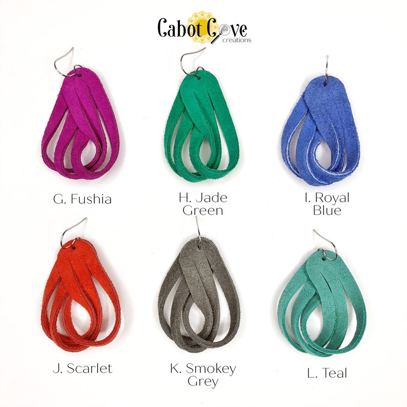 May include: Six pairs of suede earrings in various colors, including fuchsia, jade green, royal blue, scarlet, smokey grey, and teal. Each pair is made of four strands of suede, twisted together to form a teardrop shape. The earrings are labeled with letters G through L.