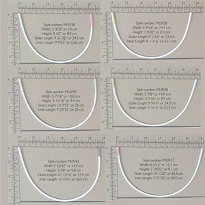May include: Four pairs of white underwire bra cups with different sizes and styles. The bra cups are laid out on a white surface with a ruler for measuring. The bra cups are labeled with style numbers and measurements in inches and centimeters.