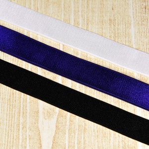 May include: Three different types of elastic ribbon, one white, one black, and one dark blue.