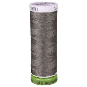May include: A spool of gray sewing thread with the text "C.A.M.A.N.N. 100% Recycled Polyester" on the label.