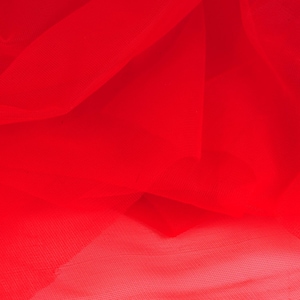 May include: Red tulle fabric with a soft, delicate texture. The fabric is draped and folded, creating a flowing and airy appearance.