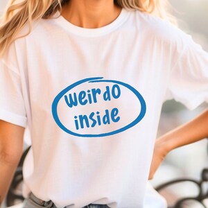 May include: White t-shirt with a blue circle and the text "weirdo inside" in a handwritten style.