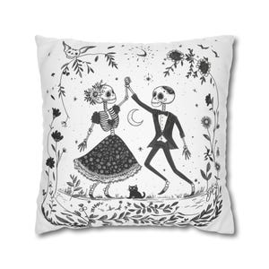 May include: A black and white illustration of two skeletons dancing with a black cat watching them. The skeletons are dressed in formal attire and are surrounded by flowers and vines. The background is white.