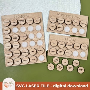 May include: A wooden grocery list organizer with three sections labeled "In Stock", "Running Low", and "To Buy". Each section has a grid of circles with labels for various grocery items. The circles are blank, suggesting they can be used as markers to indicate the status of each item.