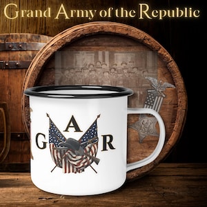 May include: White enamel mug with a black rim. The mug displays the letters "GAR" with an illustration of a hat, rifle, and American flags. The background is a wooden barrel with the text "Grand Army of the Republic".