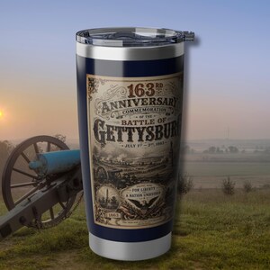 May include: A navy blue insulated travel mug commemorating the 163rd anniversary of the Battle of Gettysburg. The mug features a detailed graphic with the text "163rd Anniversary Commemoration of the Battle of Gettysburg, July 1st-3rd, 1863".