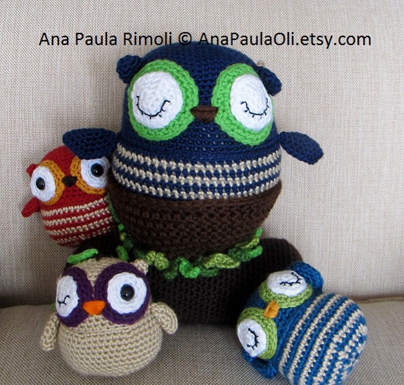 May include: Four crocheted owls in different colors and patterns. The largest owl is blue with green eyes and a brown body. The other owls are red, beige, and blue with white eyes.