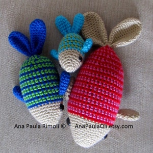 May include: Three crocheted fish toys. One is red and white, one is green and blue, and one is blue and green. The fish are all handmade and have a cute, whimsical look.