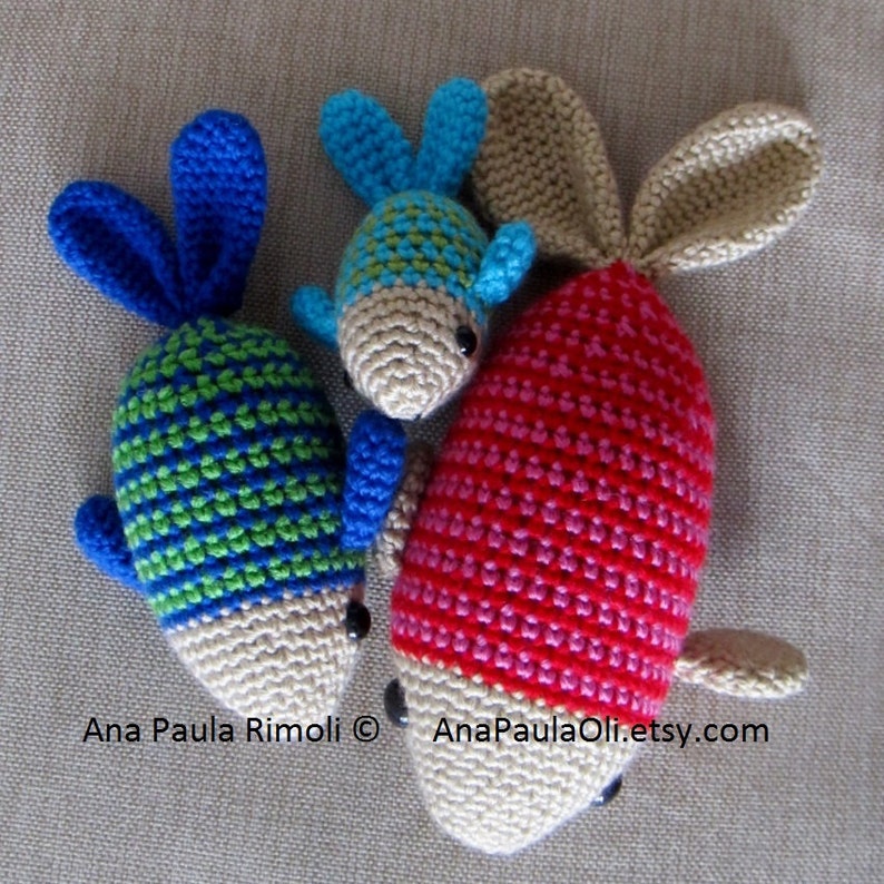 May include: Three crocheted fish toys. One is red and white, one is green and blue, and one is blue and green. The fish are all handmade and have a cute, whimsical look.