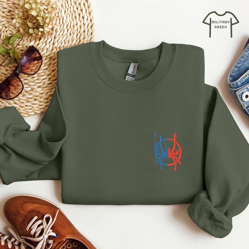 May include: A military green sweatshirt with a red and blue spider web design embroidered on the front.
