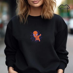 May include: Black sweatshirt with a cartoon image of Spiderman's head in a web, making a hand gesture.