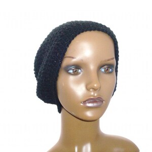 May include: A black knit beanie with a slouchy fit. The beanie is made of a soft, textured yarn.