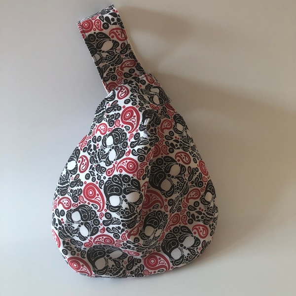 Small sized reversible Japanese Knot Bag in a red, black and white paisley skull print cotton Fabric