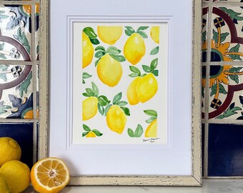 May include: A framed watercolour painting of lemons with green leaves on a white background. The painting is signed "Sharon Harmon 7/14".