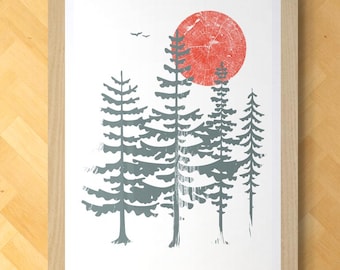 May include: A framed art print featuring a forest scene with a red sun and gray trees. The artwork is displayed on a light wood wall above a black shelf with a candle, books, and a small bowl. The frame is light wood.