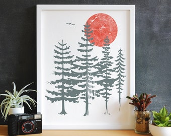 May include: A framed print of a minimalist forest scene with a large red sun and five gray trees. The sun has a wood grain texture.