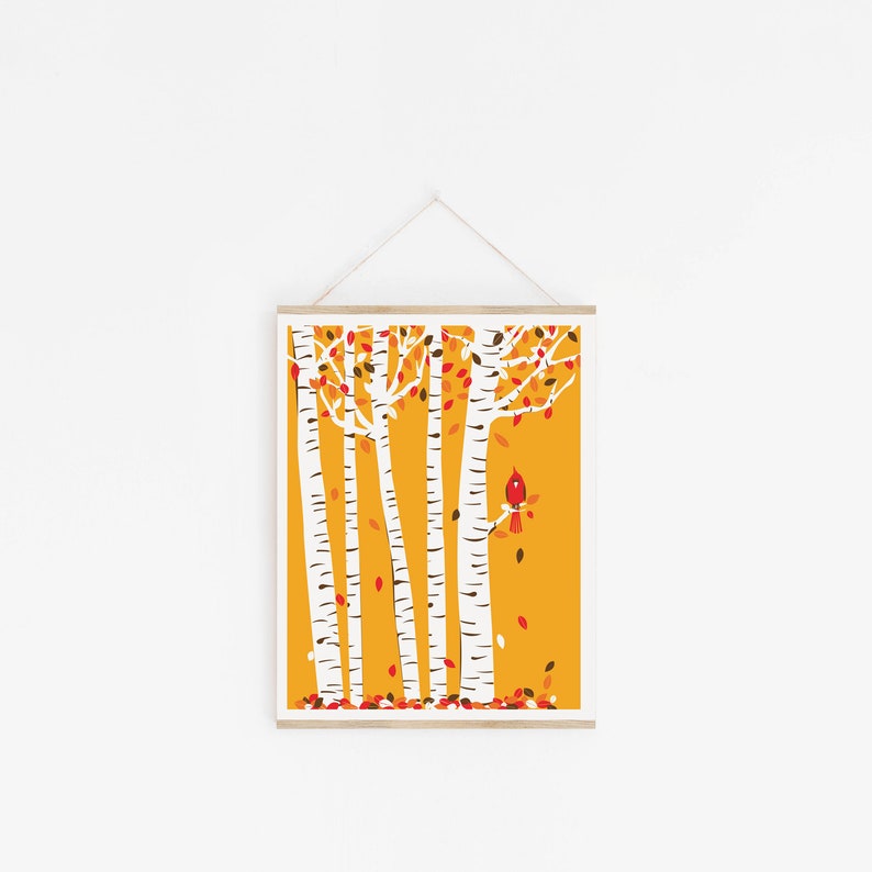 May include: A print of a forest scene with five white birch trees with red and orange leaves against a yellow background. A red cardinal bird sits on a branch of one of the trees.