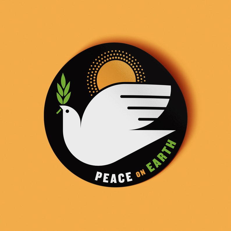May include: Black and white sticker with a white dove carrying a green olive branch. The dove is flying towards a yellow sun with a black outline. The text "Peace on Earth" is written in a black arc below the dove.