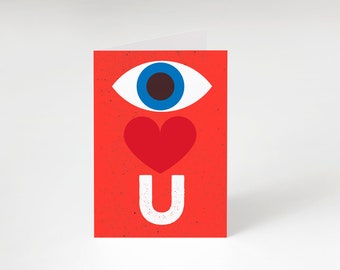 May include: Red card with a blue eye, a red heart, and the letter "U" in white. The card says "I love U".