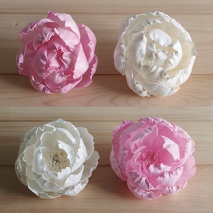 May include: Four artificial silk peonies, two white and two pink, arranged on a wooden surface.