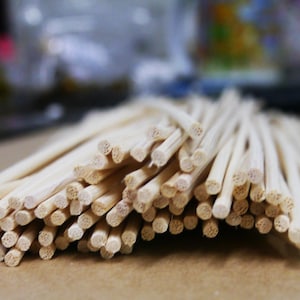 Könnte beinhalten: Ein Bündel aus natürlichen, hellbraunen Holzstäbchen. Die Stäbchen sind gebündelt und alle gleich groß. Sie werden wahrscheinlich zum Diffundieren von ätherischen Ölen oder Düften verwendet.