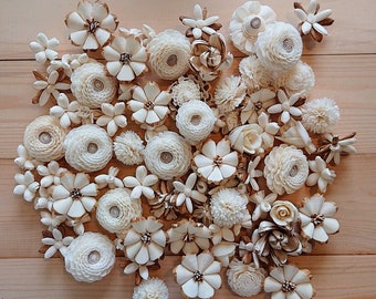May include: A collection of white and cream sola wood flower embellishments. The flowers are arranged in a cluster and feature various shapes and sizes.