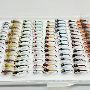 May include: A box of assorted fly fishing lures with different colored beads and feathers.