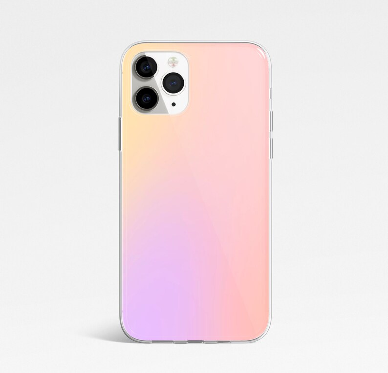 May include: A clear phone case with a gradient design that transitions from light pink to yellow. The case has a cutout for the camera lens.