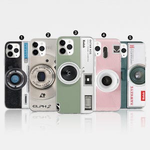 Puede incluir: Cinco fundas de teléfono diferentes con diseños de cámaras vintage. Las fundas son todas blancas con diferentes acentos de color. Las cámaras en las fundas son todas de diferentes marcas y modelos. Las fundas están todas etiquetadas con los números del 1 al 5.