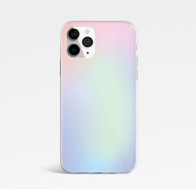 May include: A clear phone case with a gradient design that transitions from pink to blue. The case has a cutout for the camera lens.