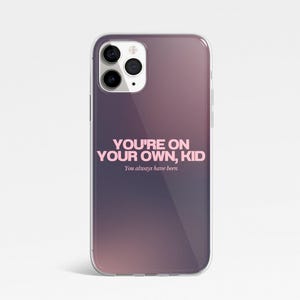 May include: A clear phone case with a purple and pink gradient. The case displays the pink text "YOU'RE ON YOUR OWN, KID", with "You always have been" underneath in a smaller font.