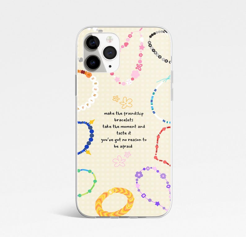 May include: A phone case with a cream background featuring colourful friendship bracelet designs and the text "make the friendship bracelets, take the moment and taste it, you've got no reason to be afraid."