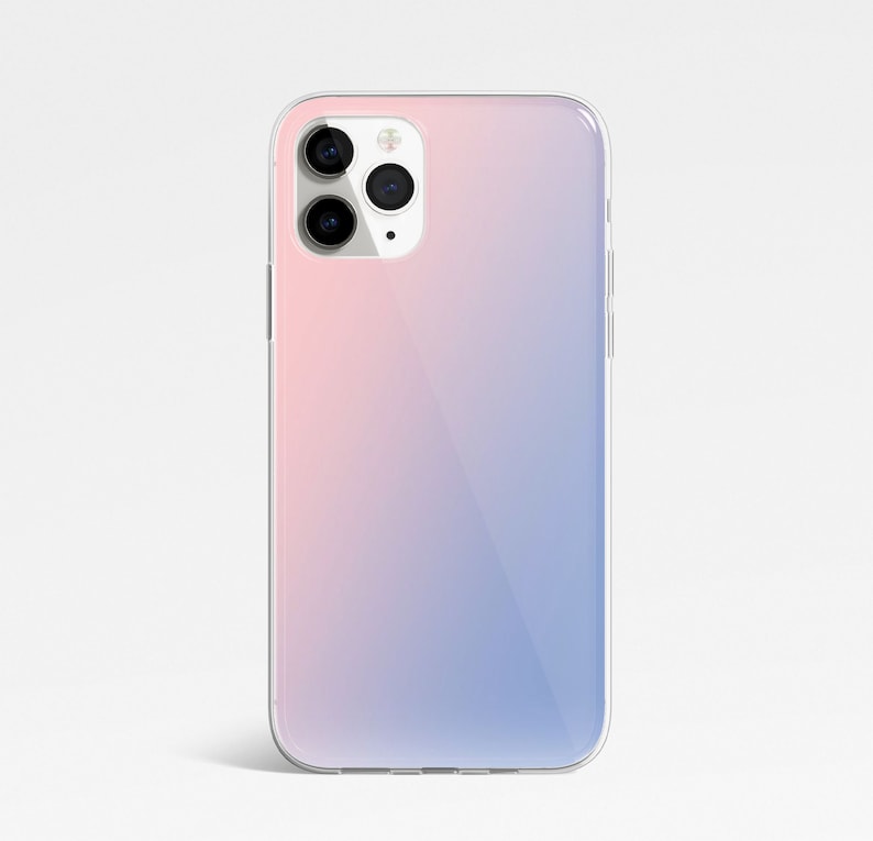 May include: A clear phone case with a gradient design that transitions from pink to blue. The case has a raised camera bump with three black camera lenses.