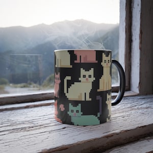 May include: A black coffee mug with a white handle features a pixelated pattern of colorful cats on a black background.
