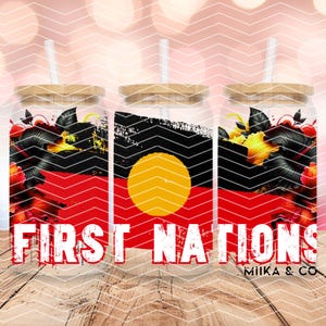 May include: Three glass tumblers with bamboo lids and straws. Each tumbler features the Aboriginal flag design with a red, black, and yellow color scheme. The words "FIRST NATIONS" are printed in white across the front. Floral accents are visible.