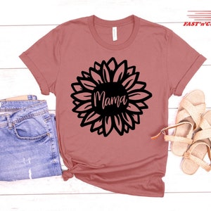 a t - shirt with a sunflower on it next to a pair of jeans