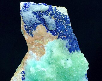 May include: A green and blue mineral specimen with a rough, textured surface. The specimen has a cluster of green crystals on one side and a layer of blue crystals on the other side.