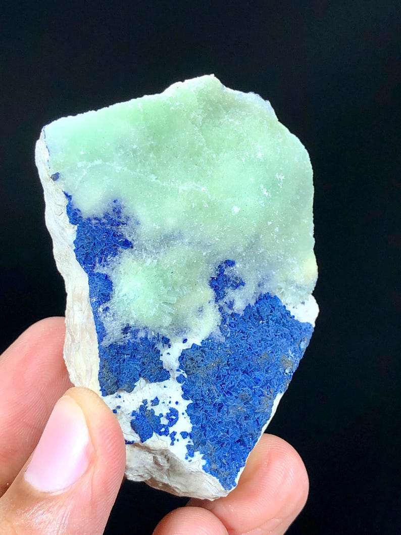 May include: A rough, light green and blue mineral specimen with a white matrix. The mineral has a crystalline structure and is a natural stone.