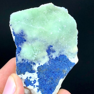May include: A rough, light green and blue crystal specimen. The crystal has a layered appearance with a light green layer on top of a blue layer.