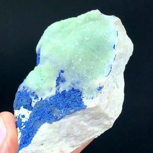 May include: A rough, light green and blue mineral specimen with a white base. The green mineral is on top of the blue mineral, which is on top of the white base.