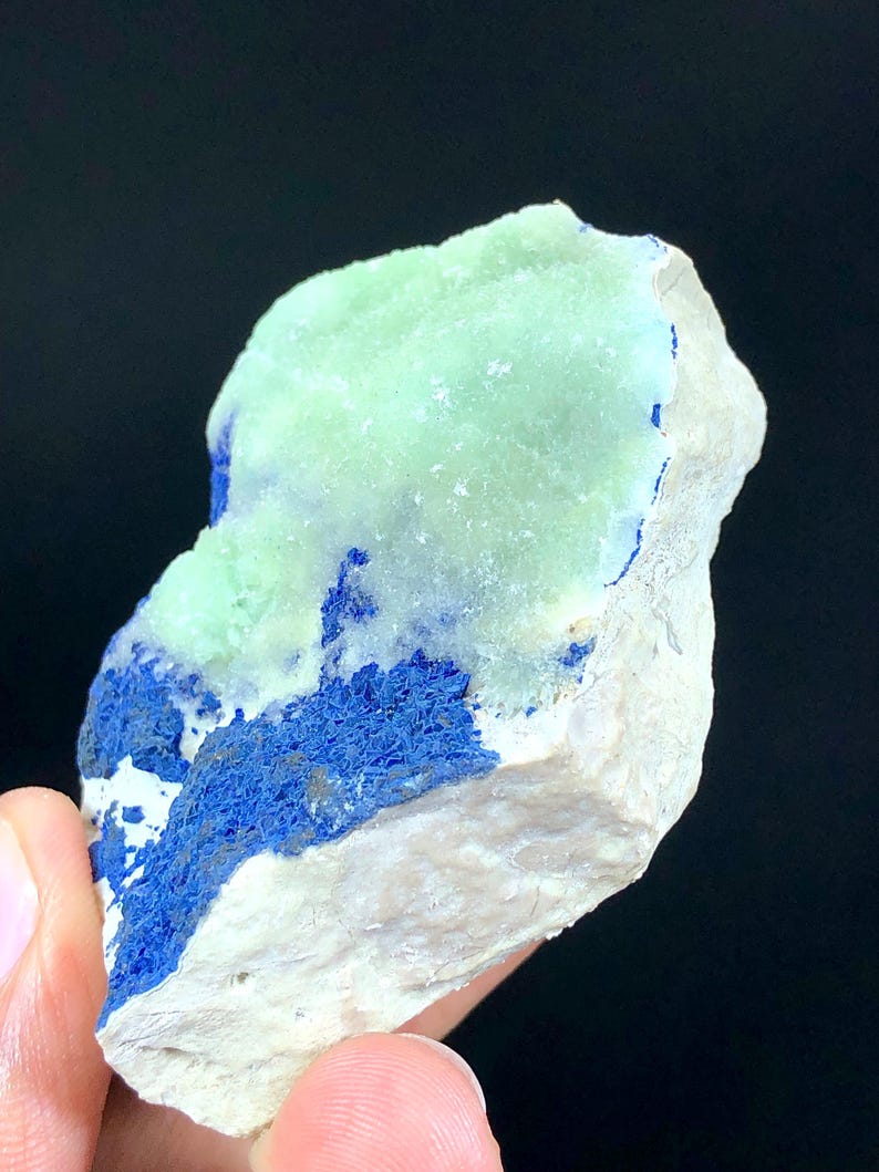 May include: A rough, light green and blue mineral specimen with a white base. The green mineral is on top of the blue mineral, which is on top of the white base.